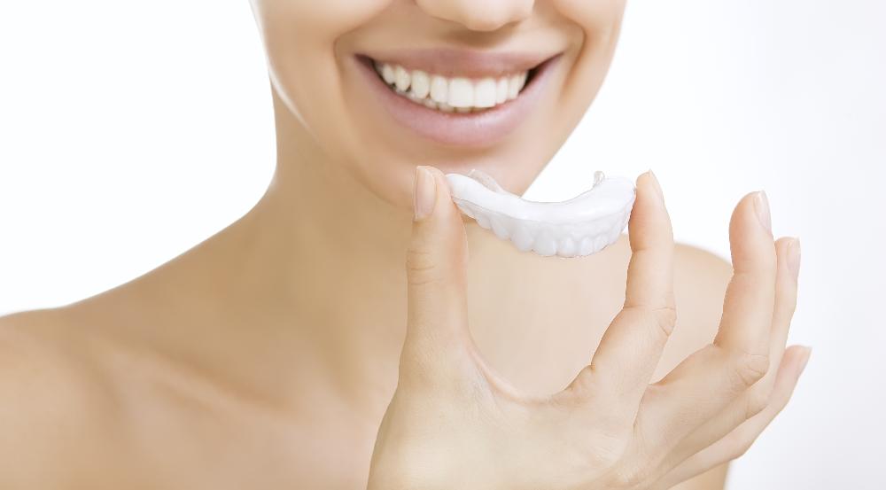 woman putting in clear plastic aligner | suresmile dentist white bear lake mn