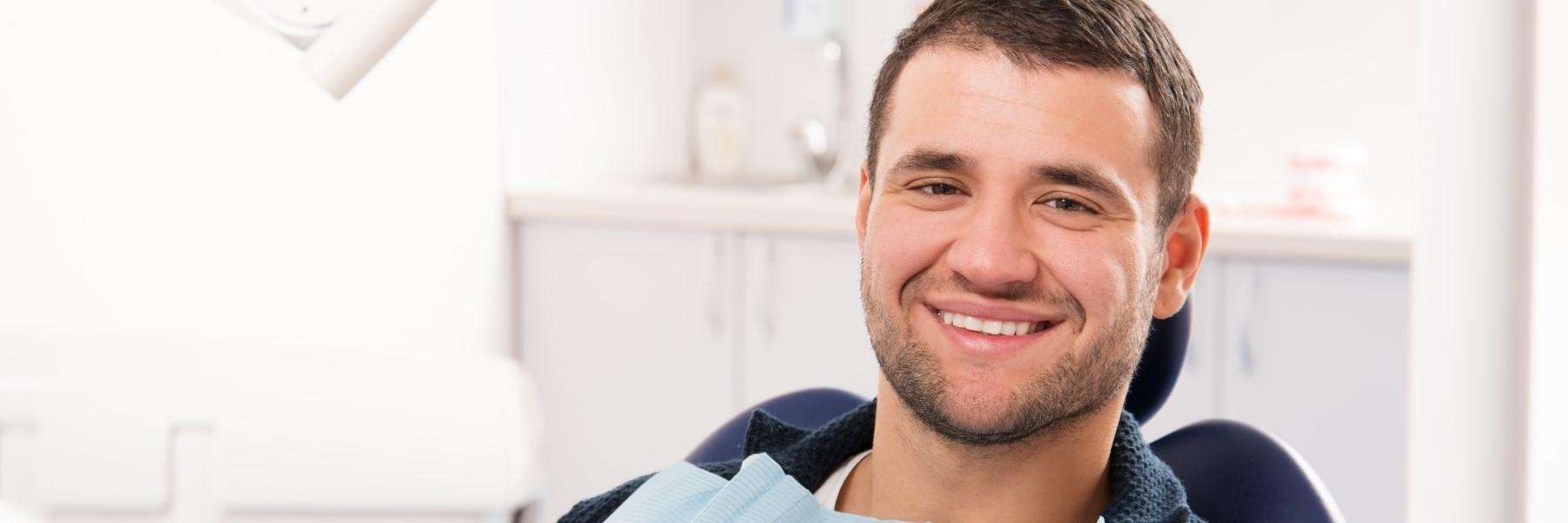 man sitting in a dental chair waiting for dental implants