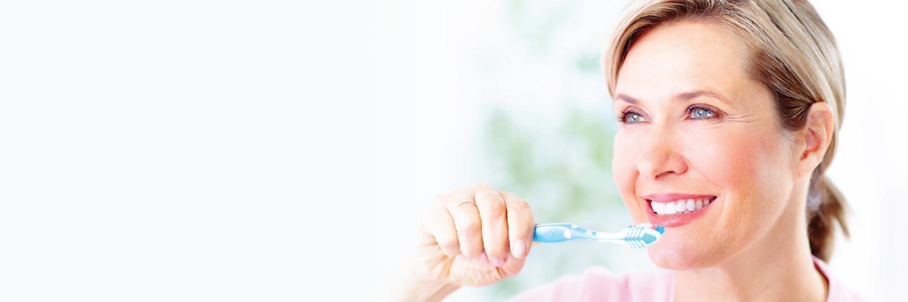 woman brushing her teeth in white bear lake, mn