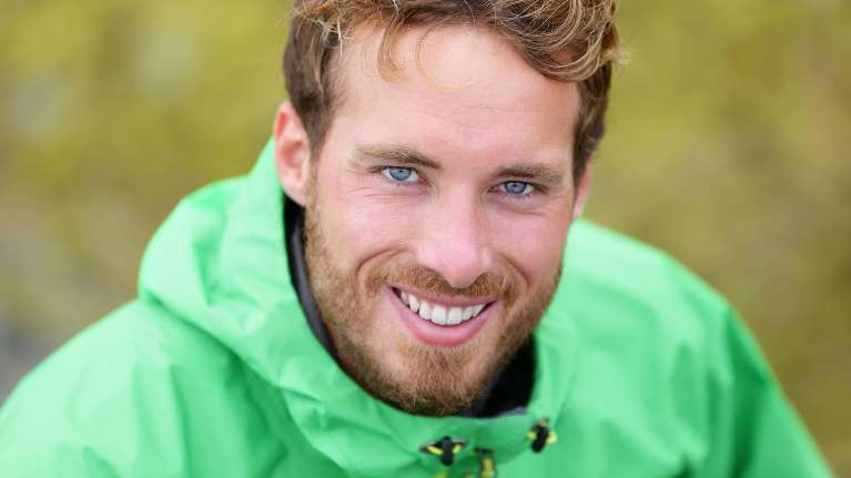 man in green jacket smiling | dental crowns white bear lake