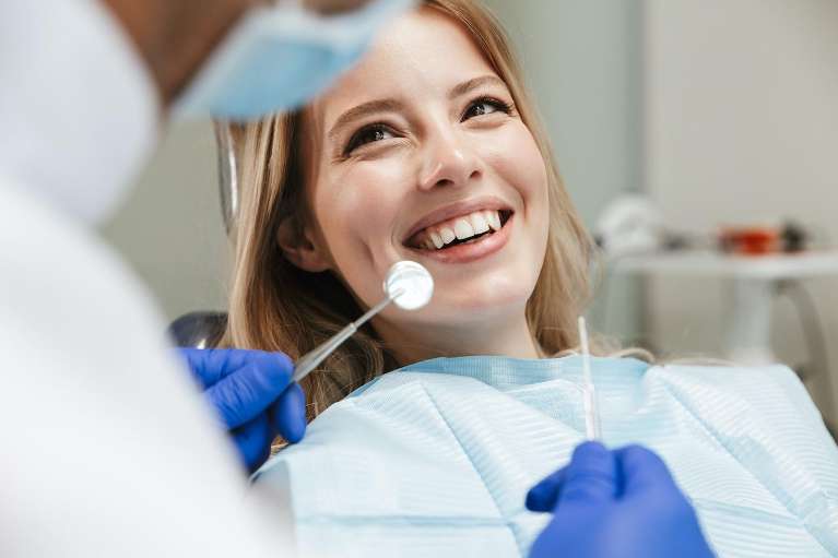 woman sitting in a dental chair getting dental cleaning